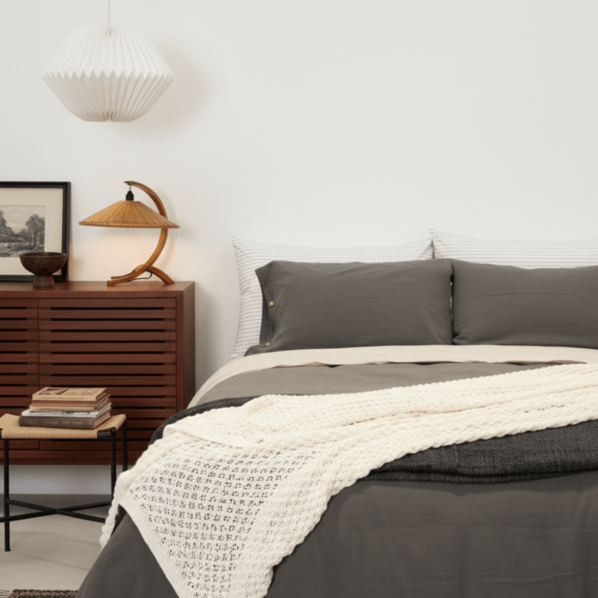 Bedroom with a bed featuring gray bedding and a wooden side table.