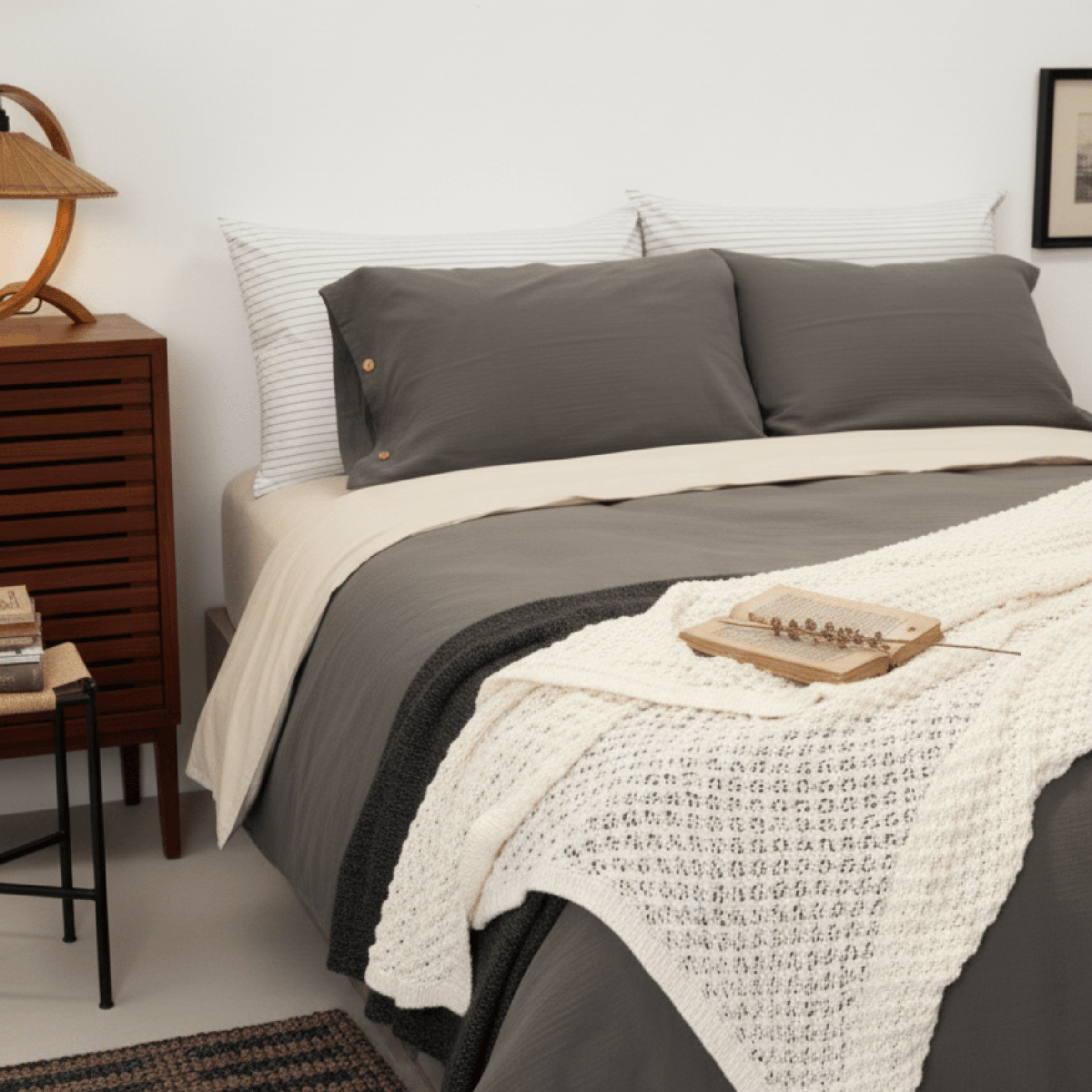 Bedroom with a bed featuring gray bedding and a wooden nightstand.