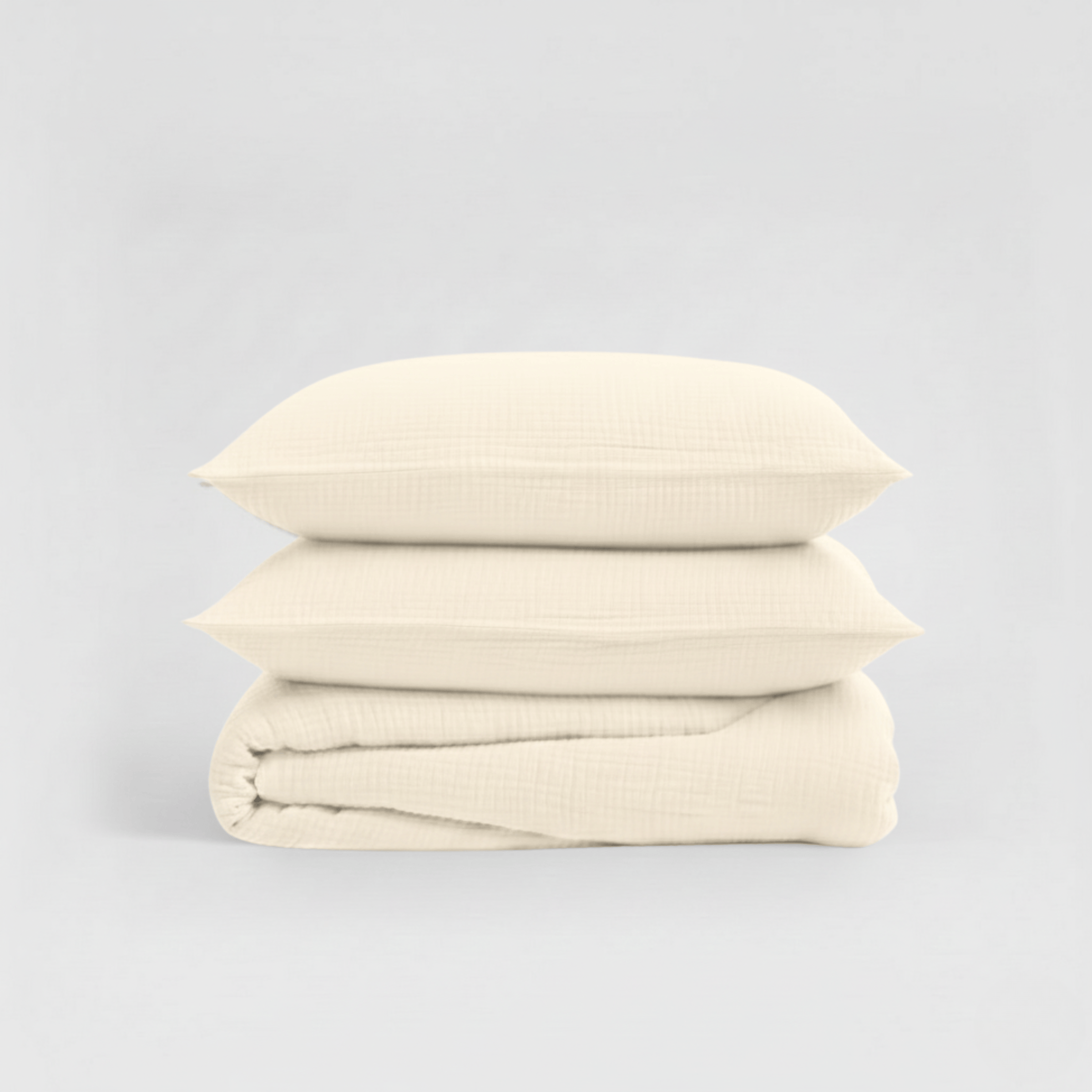 Stack of beige folded fabric on a light gray background