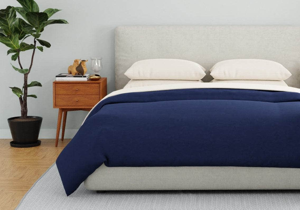 Bed with a Navy organic percale duvet cover and Dune pillowcases
