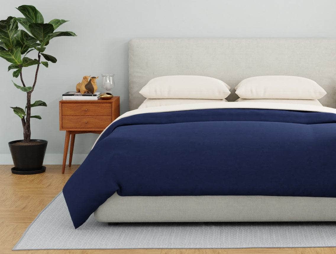 Bed with a Navy organic percale duvet cover and Dune pillowcases