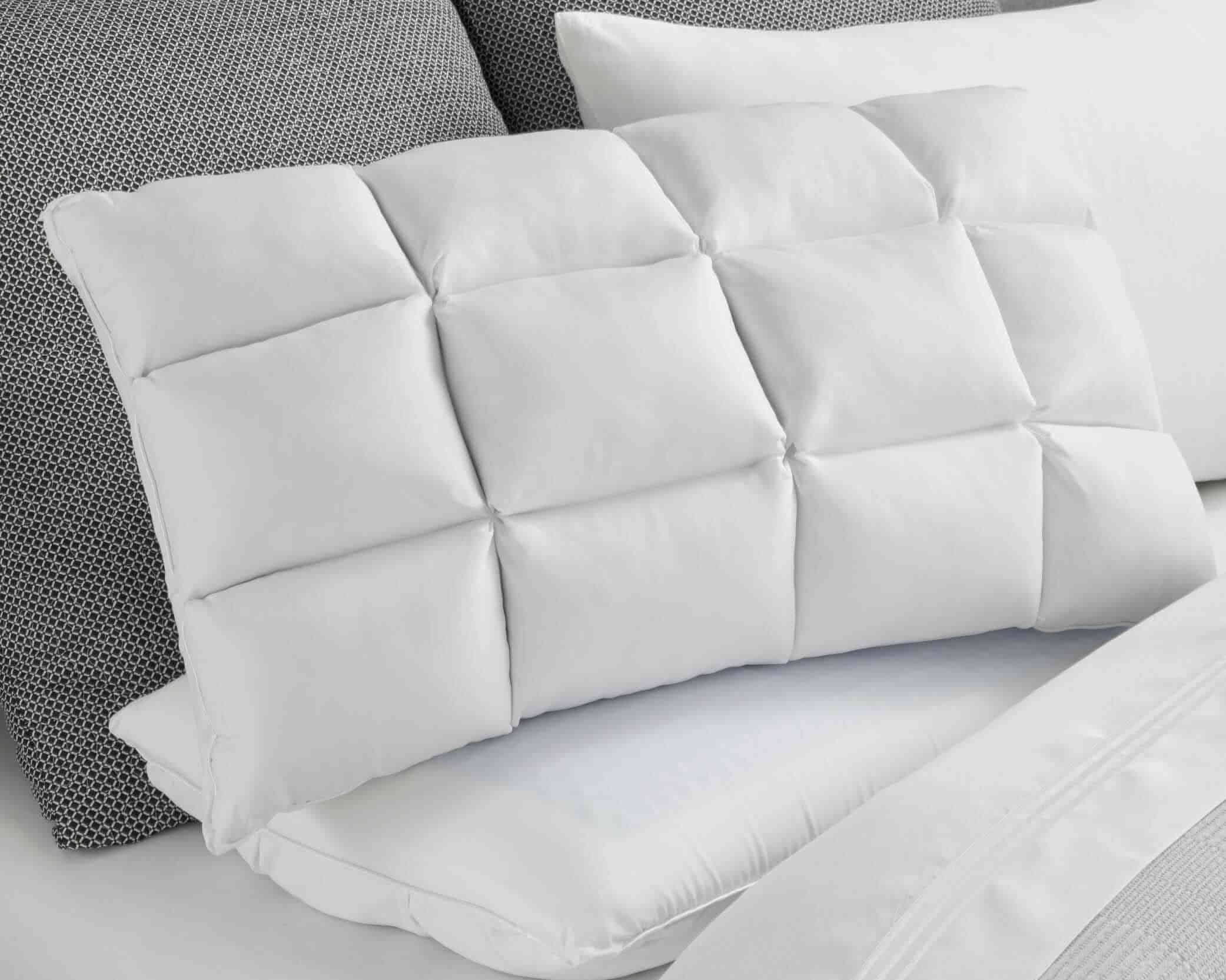 Image of a Cooling SoftCell® Chill Pillow on a gray and white bed with the SoftCell side facing forward
