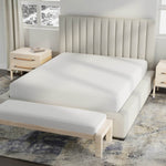 Image of a bed in a neutral colored room with just a white Cooling 5-Sided Mattress Protector on the bed