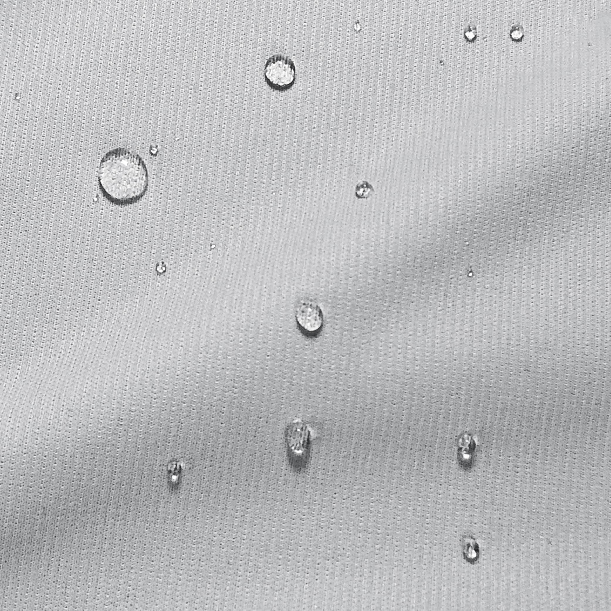 Close-up image of Cooling Mattress Protector fabric with water droplets on top demonstrating its moisture-wicking properties