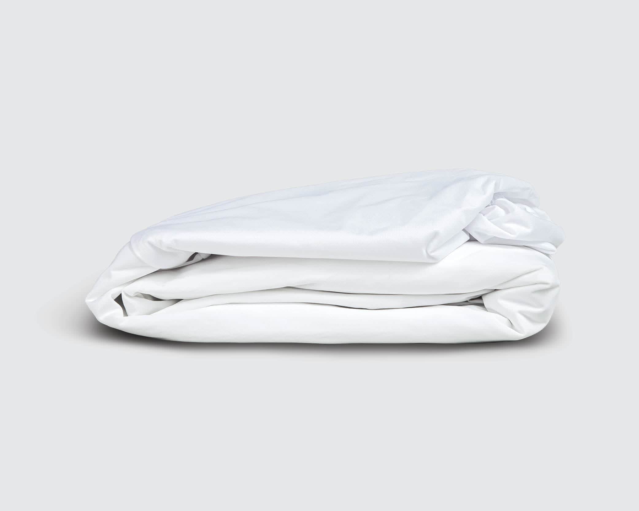 Image of a folded white mattress protector on a white background