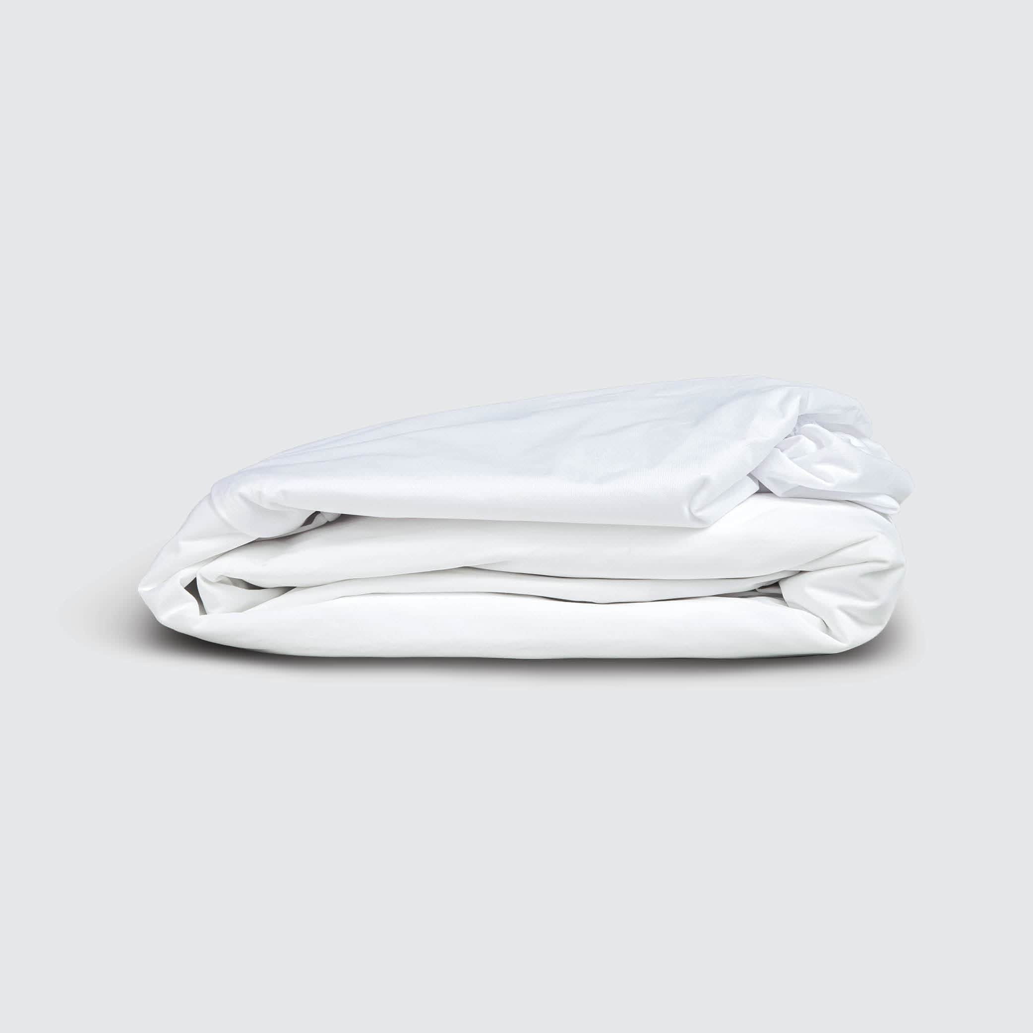 Image of a folded white mattress protector on a white background