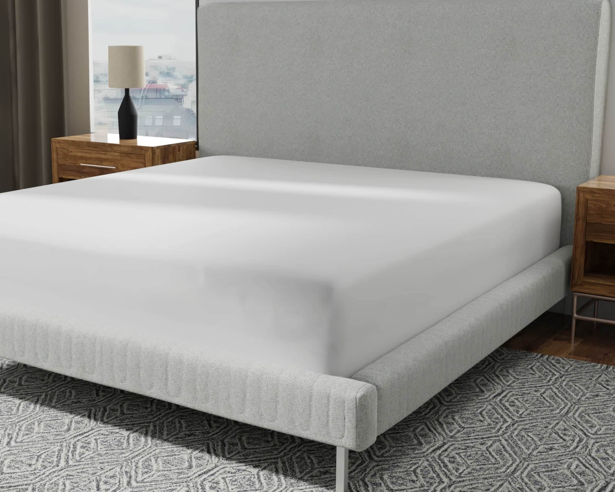 Image of a mattress protector on a bed with a gray headboard