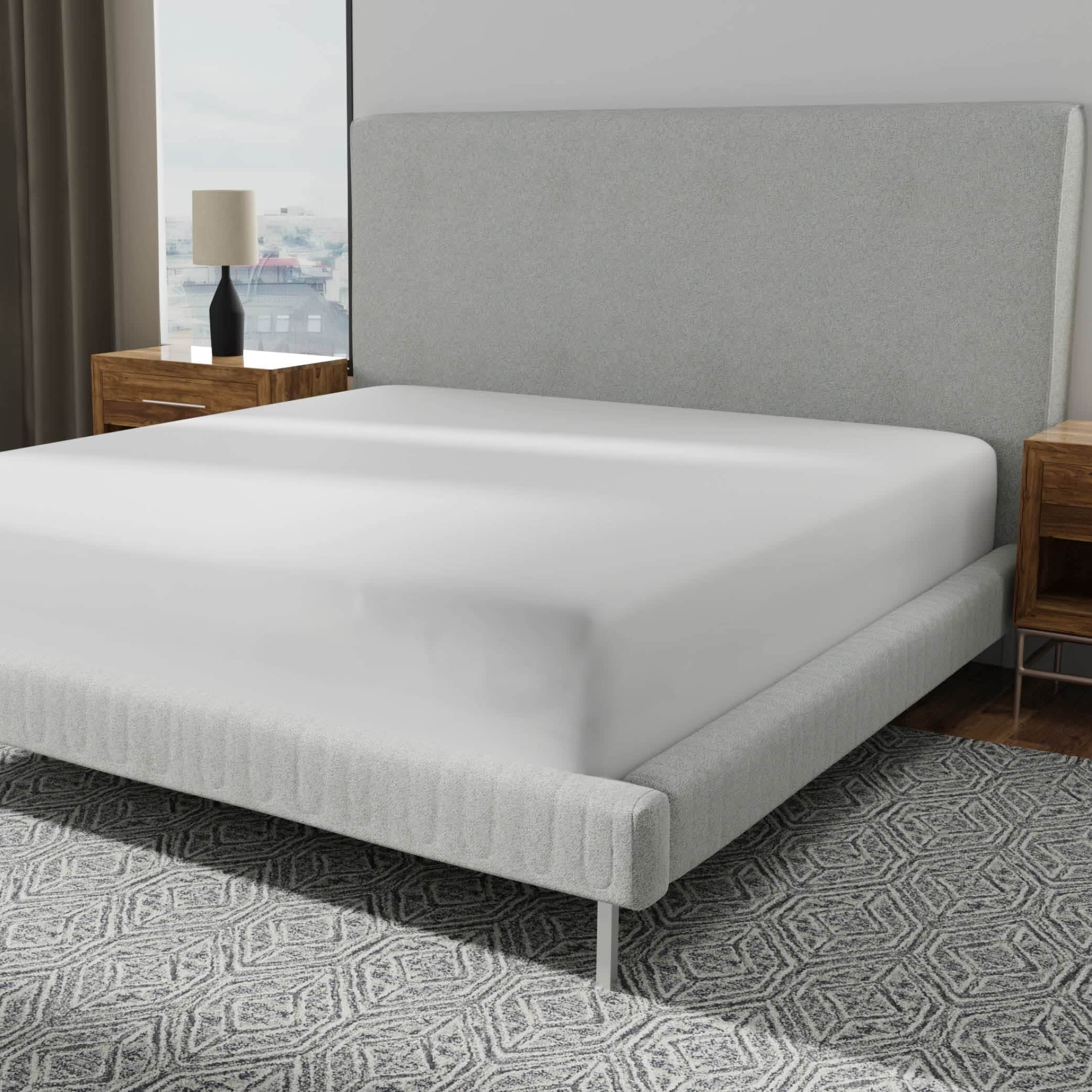 Image of a mattress protector on a bed with a gray headboard