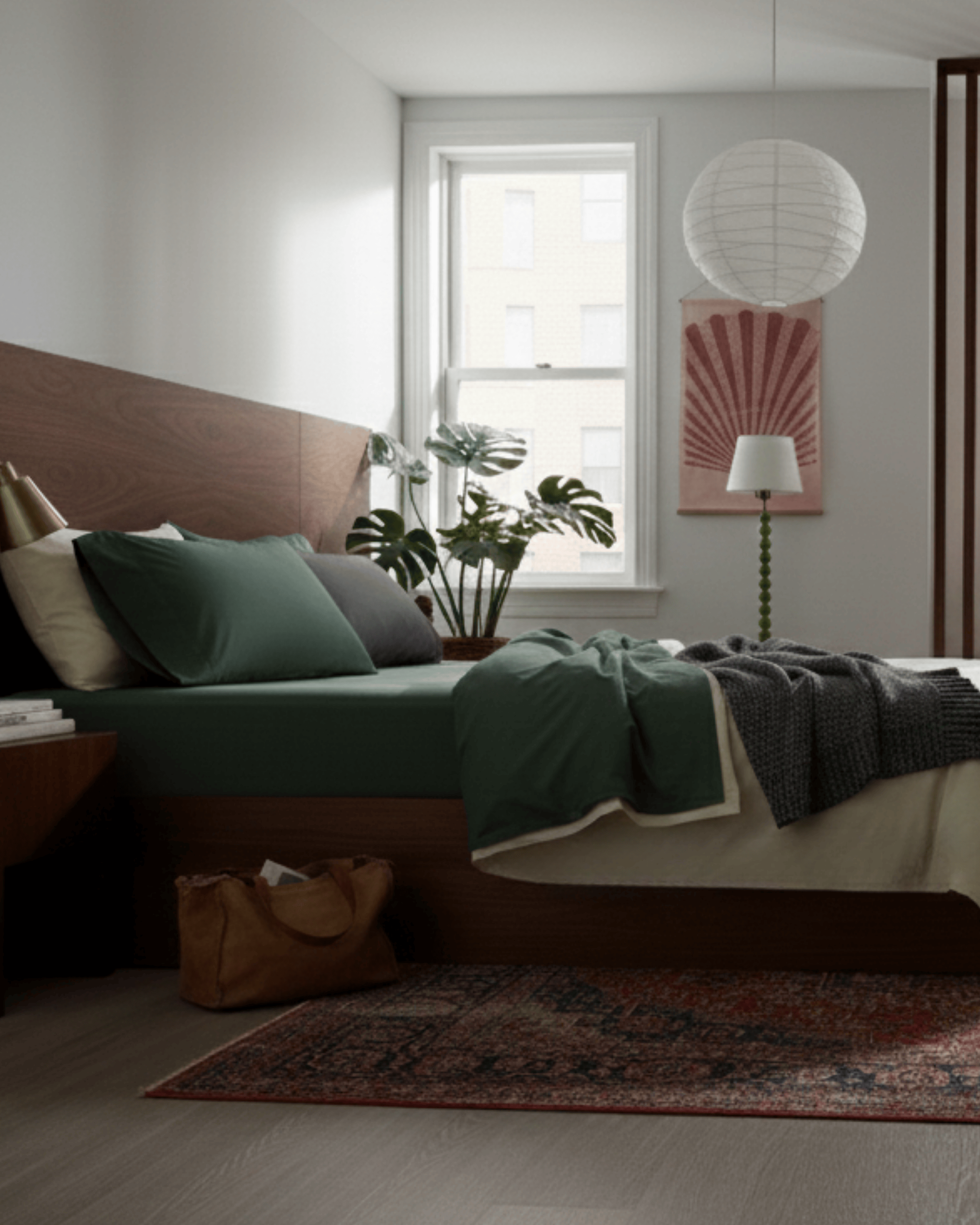 Cozy bedroom with a bed, pillows, and a plant near a window.