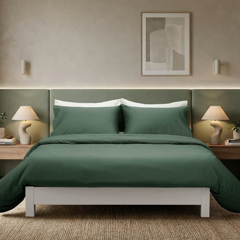 Green bedspread on a bed in a bedroom with lamps and artwork.