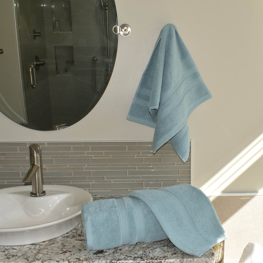Element Turkish Cotton Towel Set in Blue rolled up on bathroom counter and hand towel hung next to mirror
