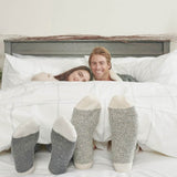 Man and Woman Laying under percale duvet with cozy socks