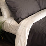 Side close up of bed with Essential Collection Percale Sheet Set in Charcoal and Light Grey Frame
