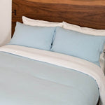 bed with blue mist linen duvet cover  and white linen sheet set