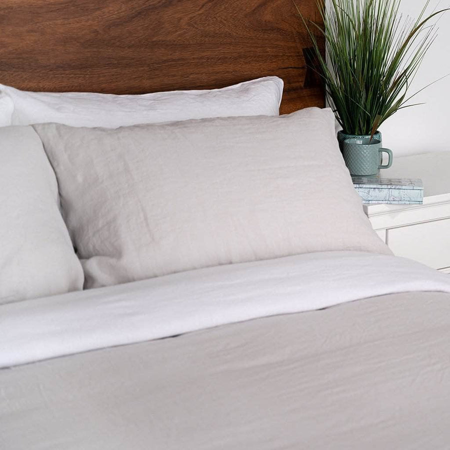 Close up of bed with Linen Duvet Cover in Mushroom and with Linen Sheet Set in White