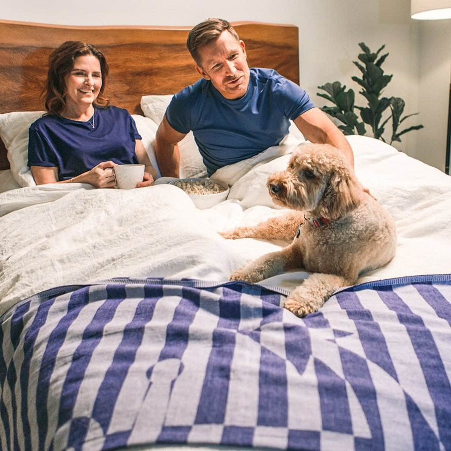 Couple relaxing with their dog in bed featuring Linen Duvet Cover in White