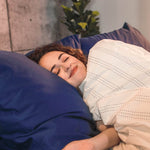 Woman sleeping in bed with Essential Collection Percale Sheet Set in Navy