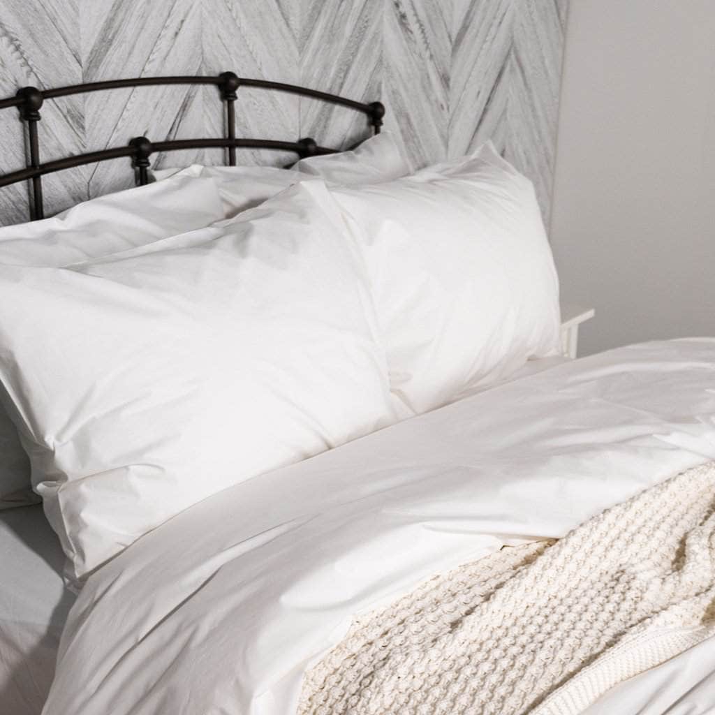 Bed featuring the Essential Collection Percale Pillowcases in White