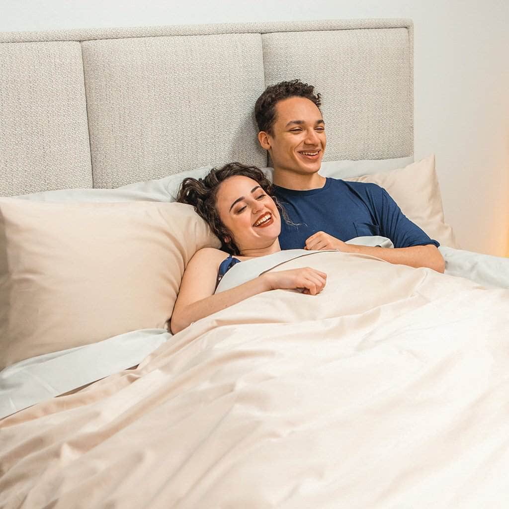 Couple laying in bed sateen sheets